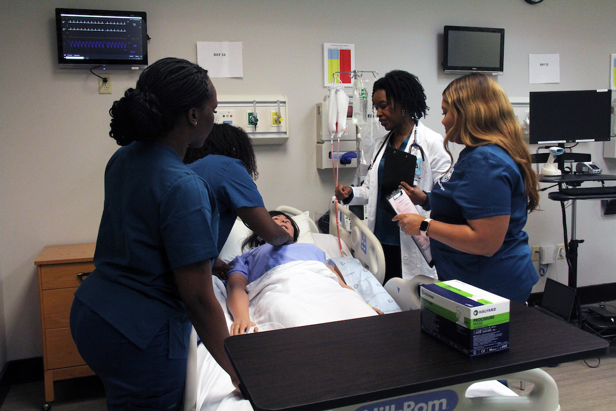 四名护士在模拟人体模型上练习医疗程序