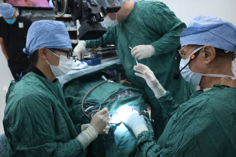 两名植牙科住院医师与希尔特·塔图姆医生一起进行植牙手术