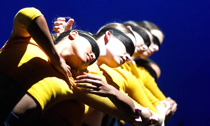 一组四名女舞者戴着黑布面具摆出戏剧性的姿势