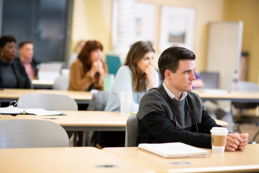 学生坐在课堂上专心地听教授讲课。